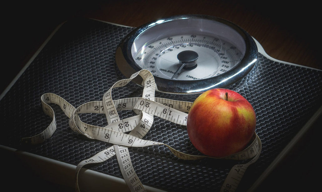 Scale with a waist ruler and an apple