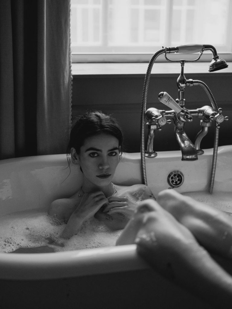 Black and white photo of Frankie Miles in a bubble bath