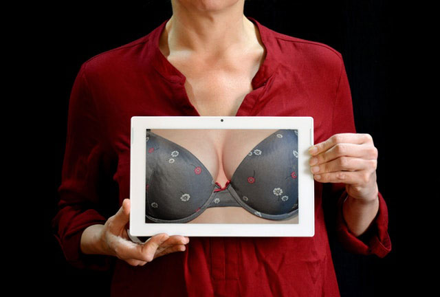 woman holding a photo of her breast in bra