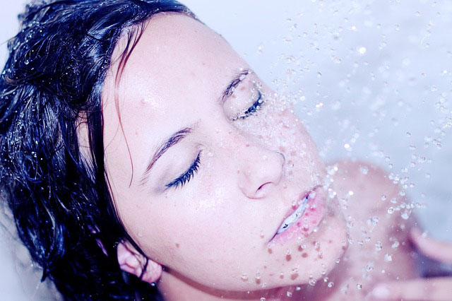 girl washing her face with water