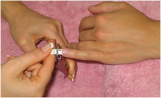 cutting acrylic nail of pinky finger