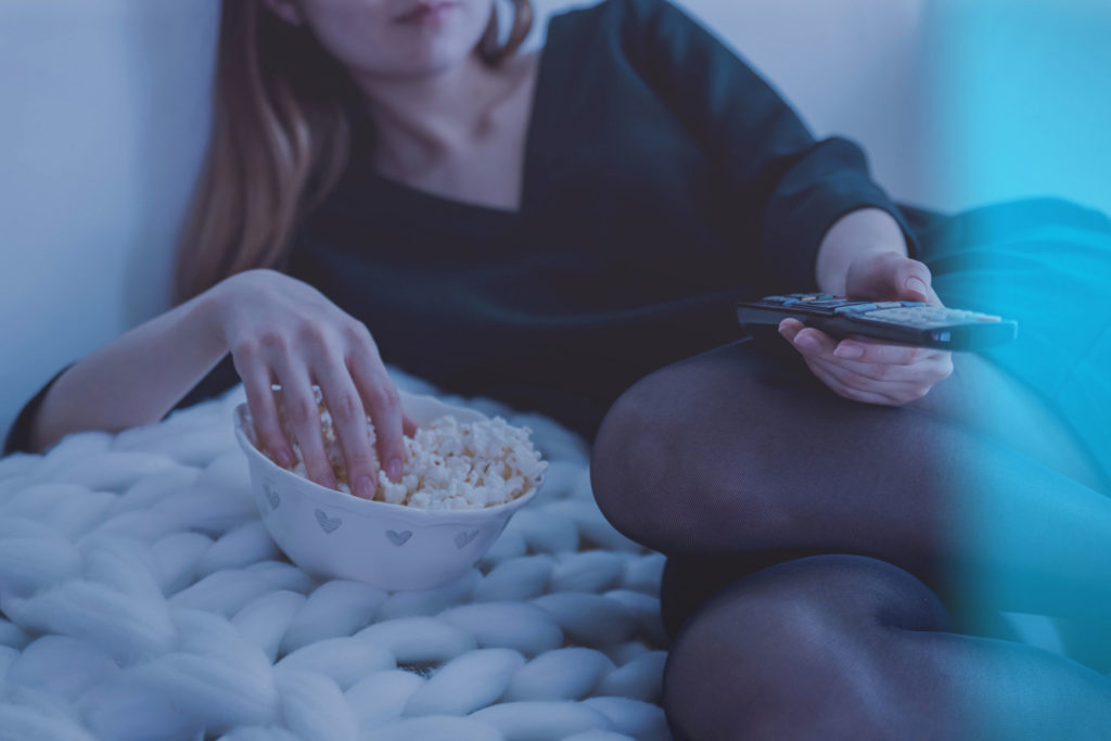 girl watching television with popcorn