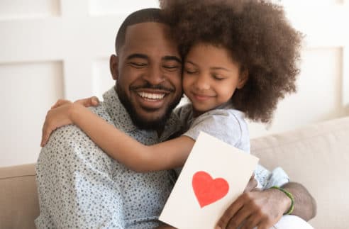 Happy Affectionate African American Dad Embracing Stock Photo