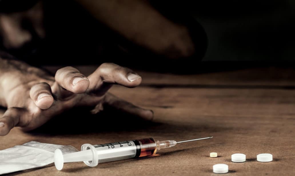 Addict man grab drug syringe of heroin.Social disaster and epidemic of narcotic addiction concept.