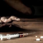 Addict man grab drug syringe of heroin.Social disaster and epidemic of narcotic addiction concept.