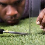 Closeup Man Cutting Green Grass Measured
