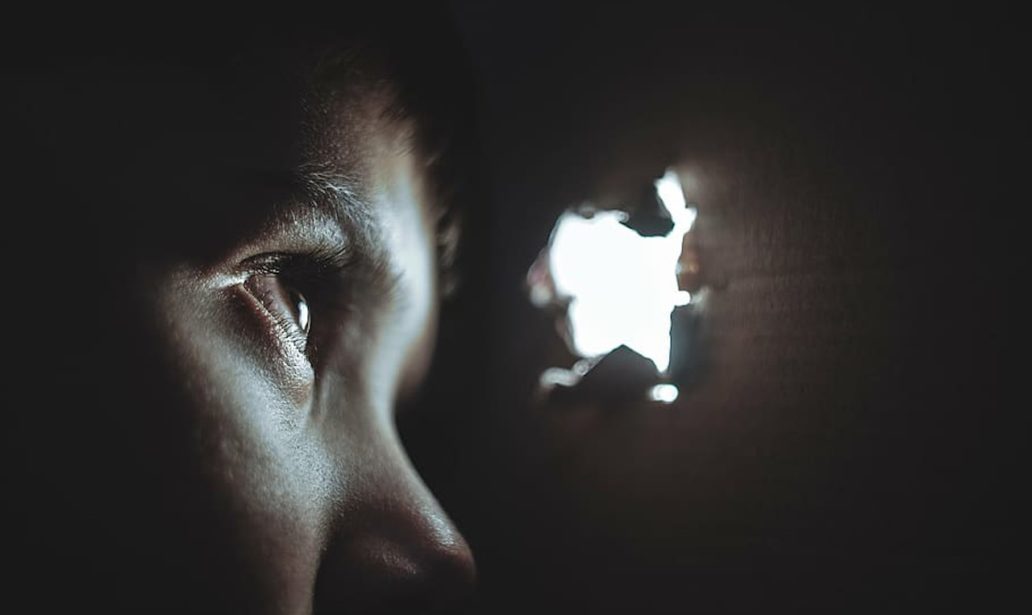 boy peeking through a hole