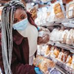 black woman choosing bread in baking department