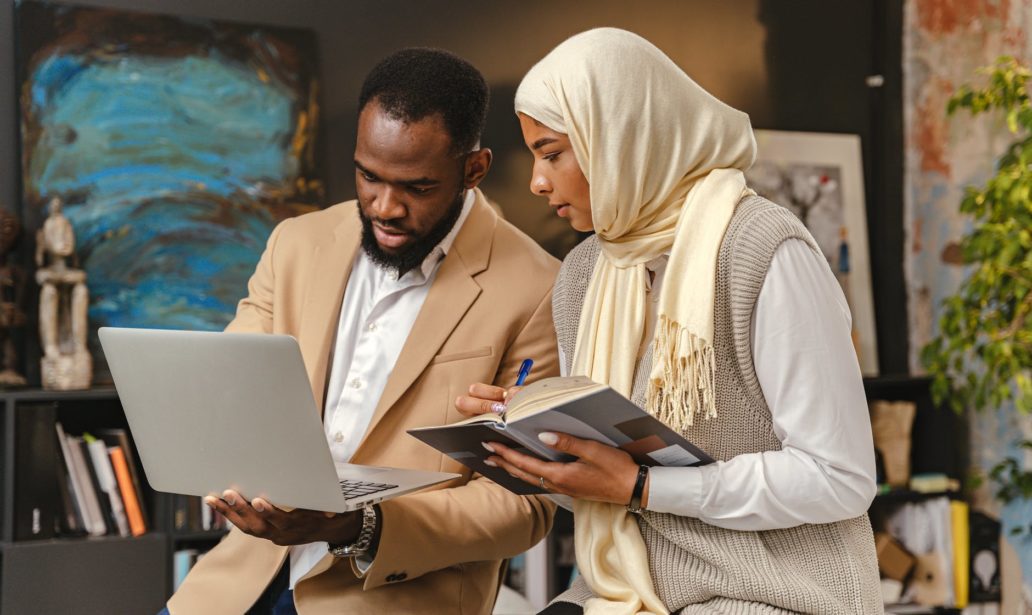man and a woman looking at a laptop