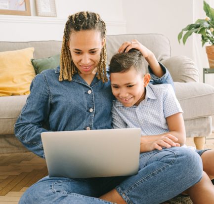 Woman and Young Boy Sitting on Floor with Laptop