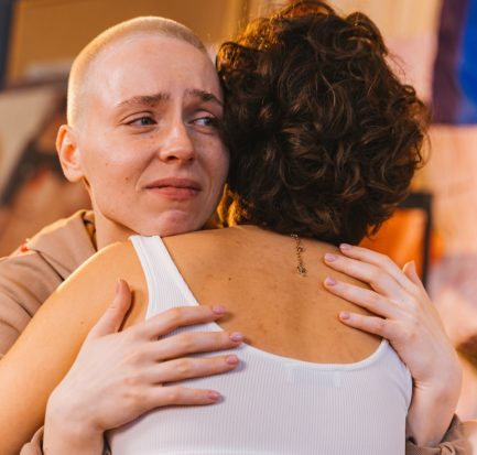 woman hugging another sad woman