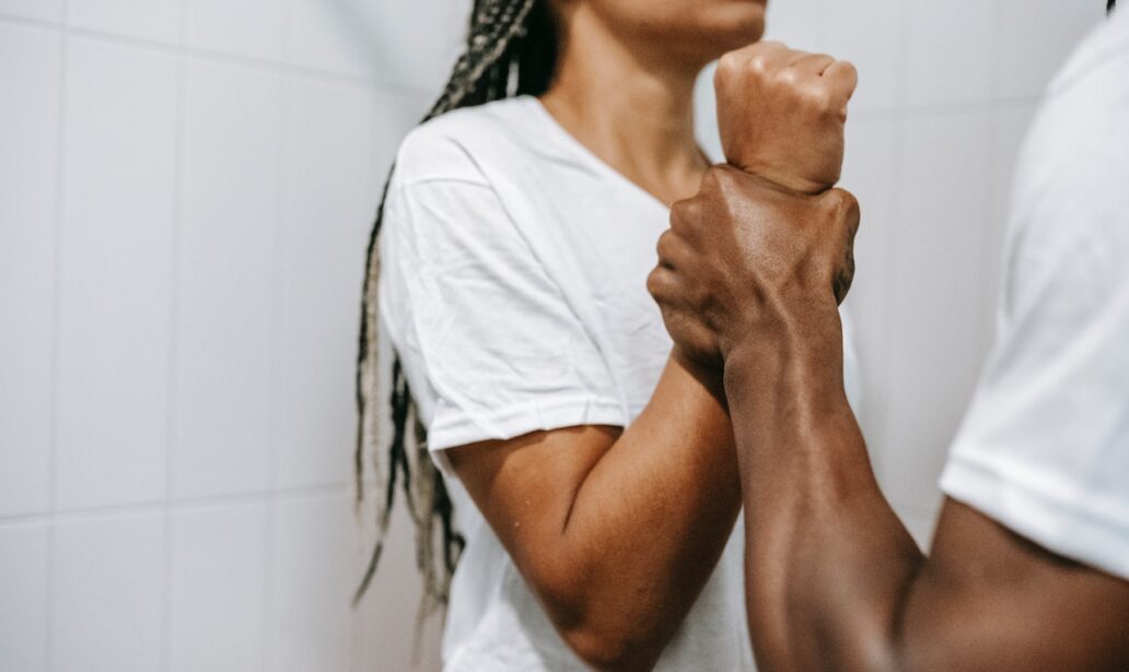 faceless muscular ethnic man grabbing wrist of girlfriend during dispute