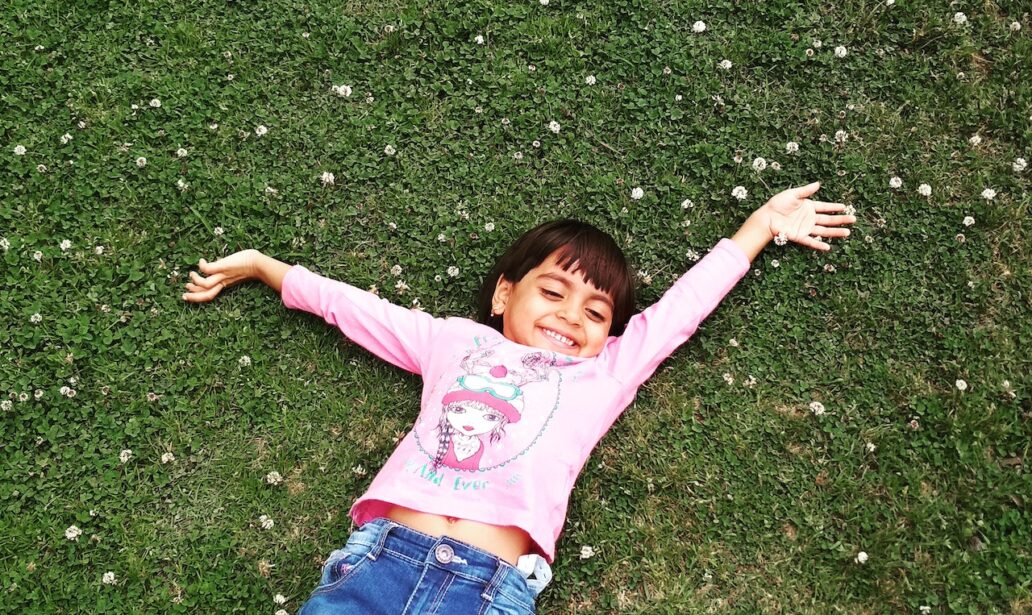 girl laying on green grass