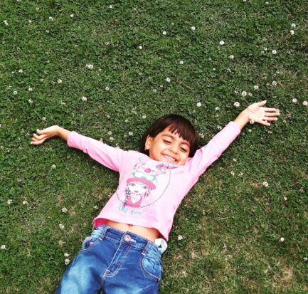 girl laying on green grass