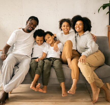 smiling black family resting on a couch