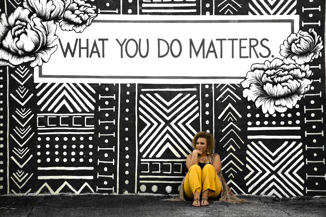 woman in yellow pants in front of a sign that says what you do matters