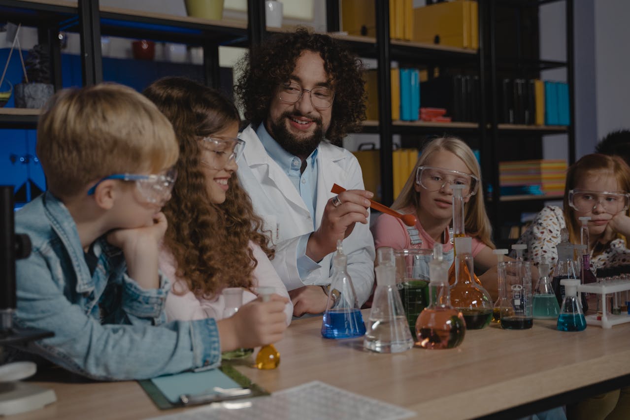 teacher and student with colored liquids in beakers and flasks