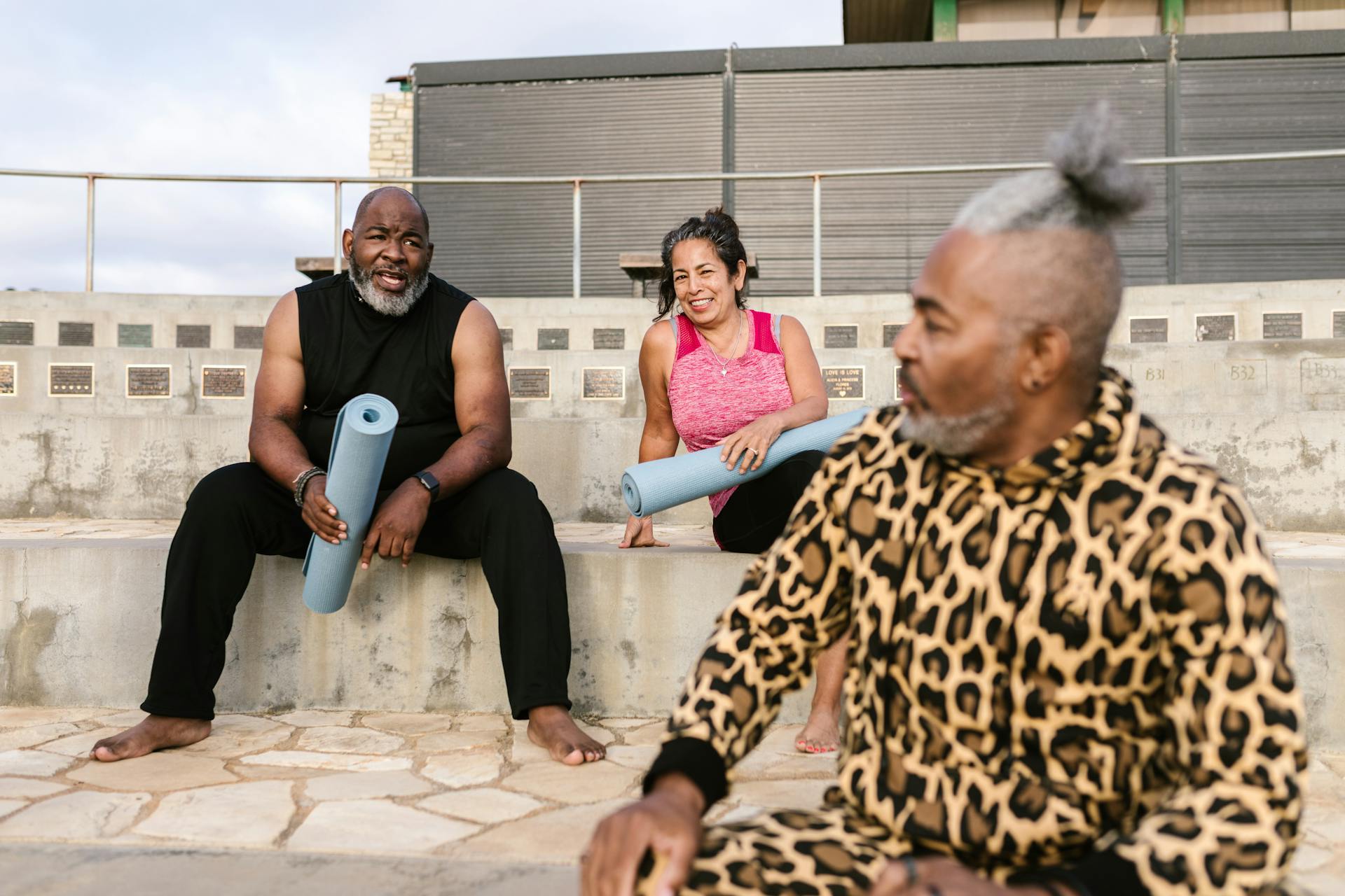 two men and woman talking after doing yoga