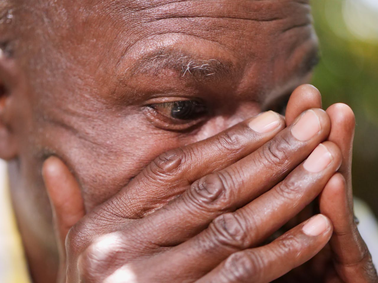 close up shot of a lonely man covering his face with his hands