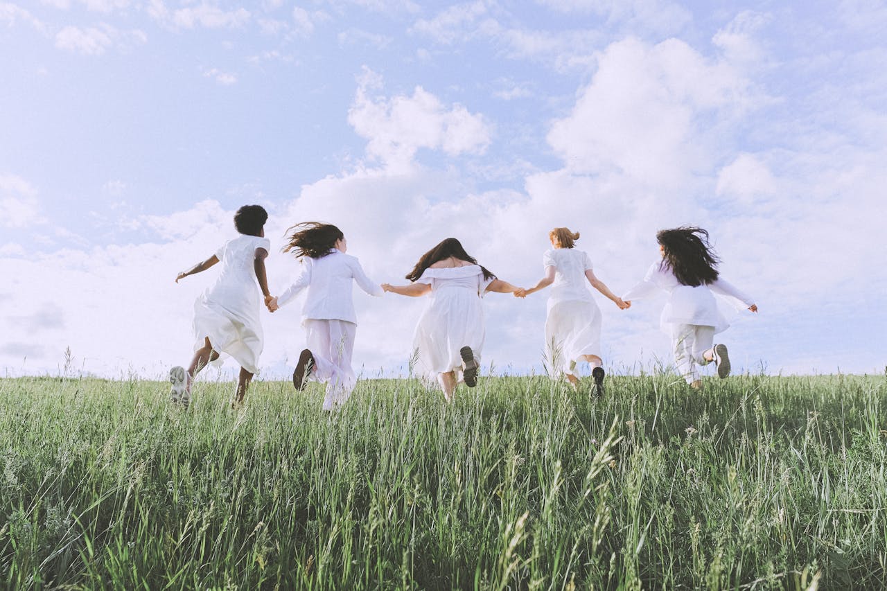 group of women running on green grass field