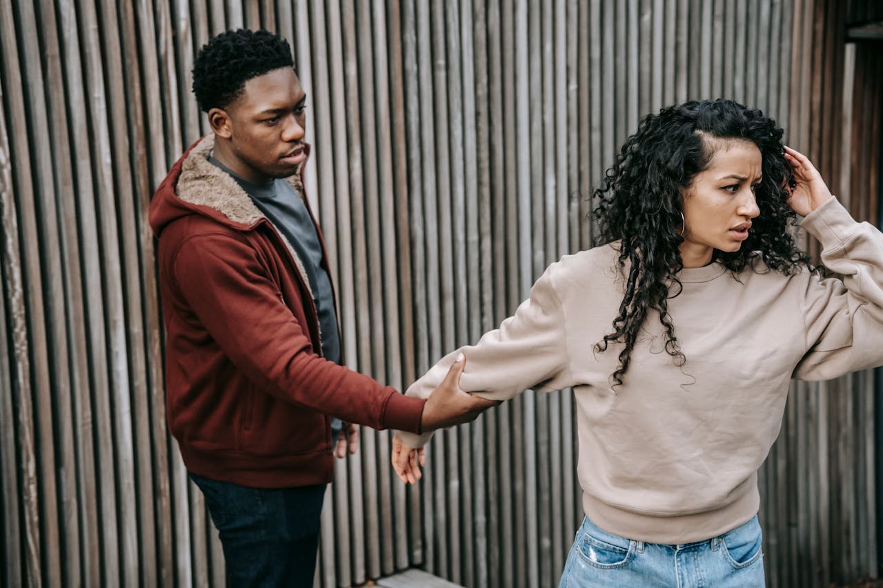 man grabbing hand of insulted woman