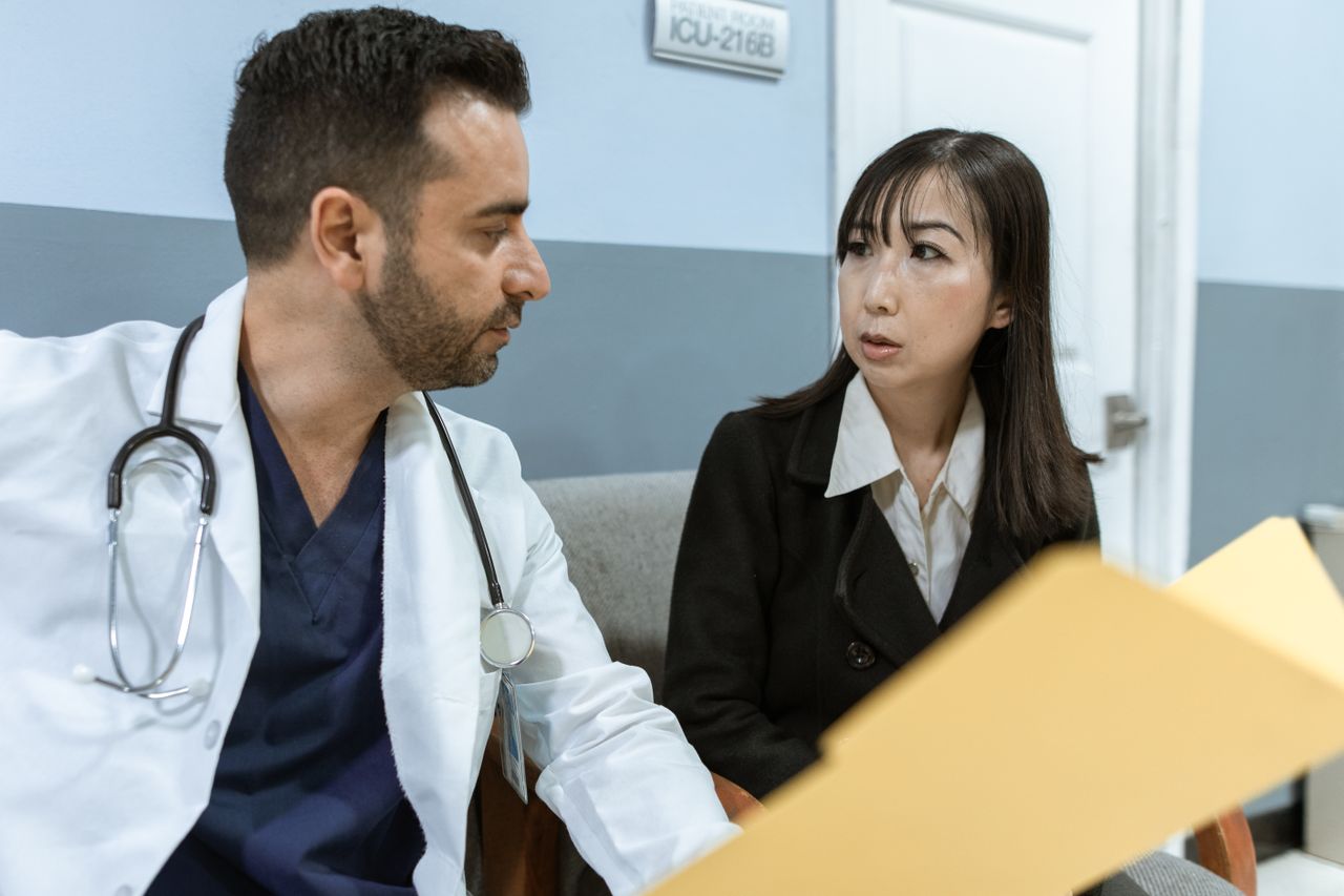 Male doctor talking to female patient