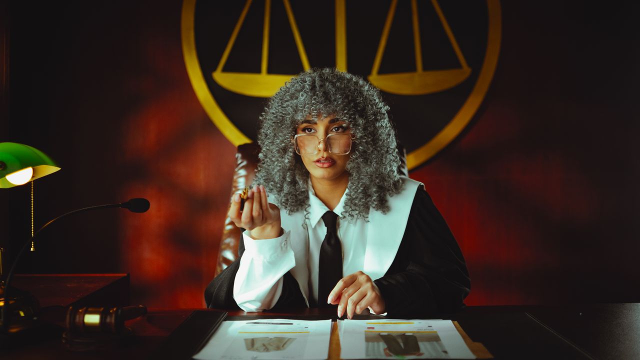 judge in courtroom holding scales of justice