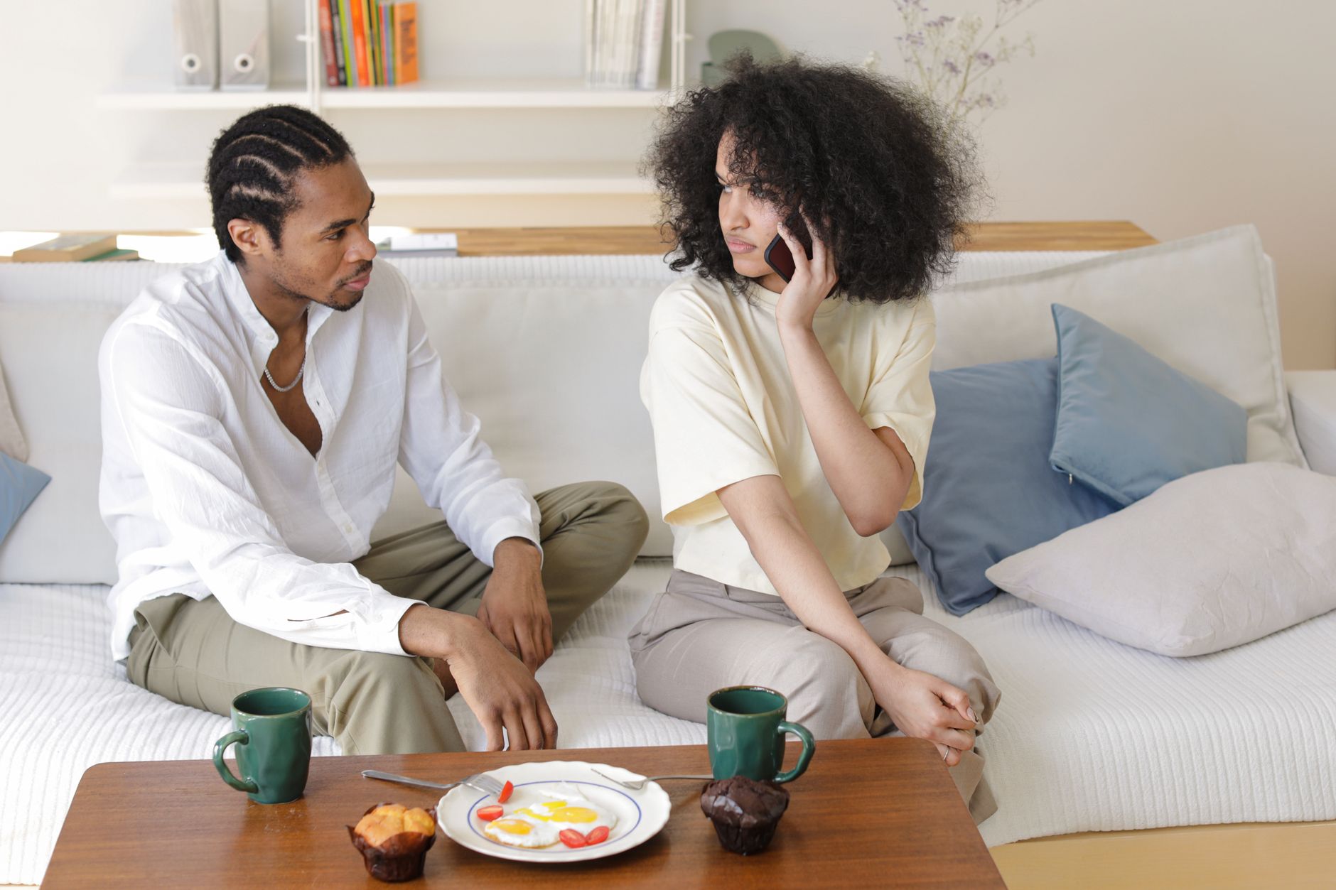 a man and woman sitting on couch looking at each other