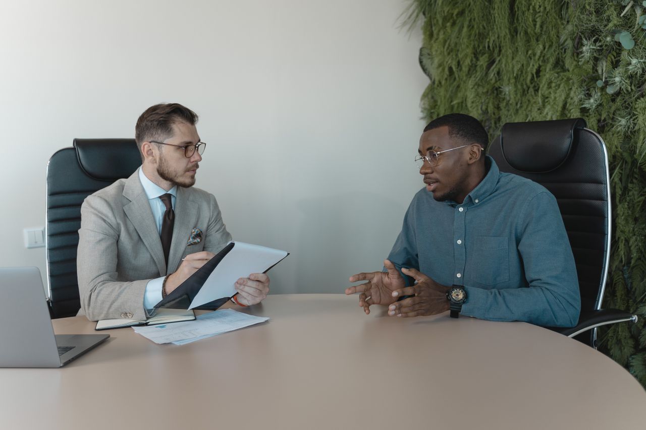 man in blue dress shirt talking in interview