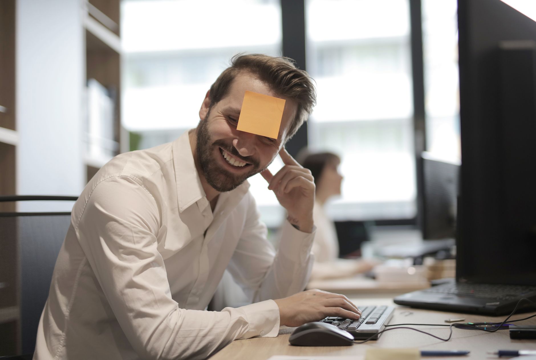 man in white dress shirt with post it note on his forehead
